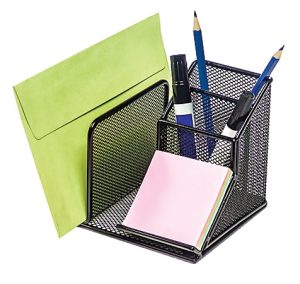 Black wire mesh organizer holding a green envelope, pink sticky notes, two blue pencils, and two black markers.