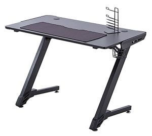 Black gaming desk with angled legs, cup holder, and headset hook, featuring a large mouse pad covering most of the surface.