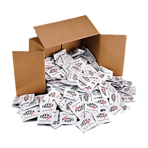 Open cardboard box spilling numerous small white snack packets onto the surface.