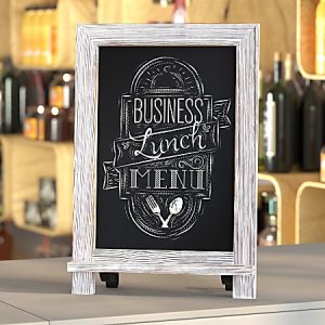 Chalkboard sign on a table displaying "Business Lunch Menu" with decorative font, set against a bar backdrop.