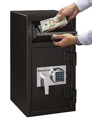 Person inserting stack of cash into a black SentrySafe depository safe with digital keypad and handle.
