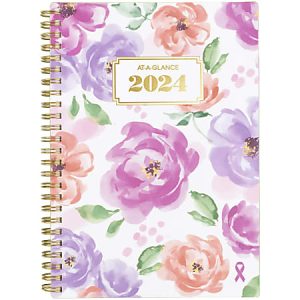 2024 planner with colorful floral design, gold spiral binding, and a pink ribbon symbol in the corner.