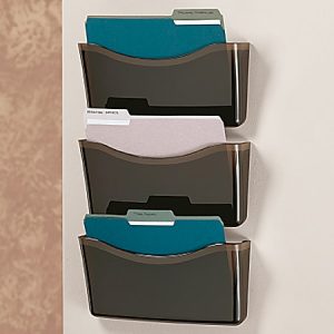 Three-tiered wall file organizer with folders in black compartments mounted on a beige wall.