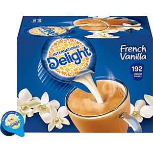 Box of International Delight French Vanilla coffee creamer singles, depicting a creamer pouring into coffee with vanilla flowers.